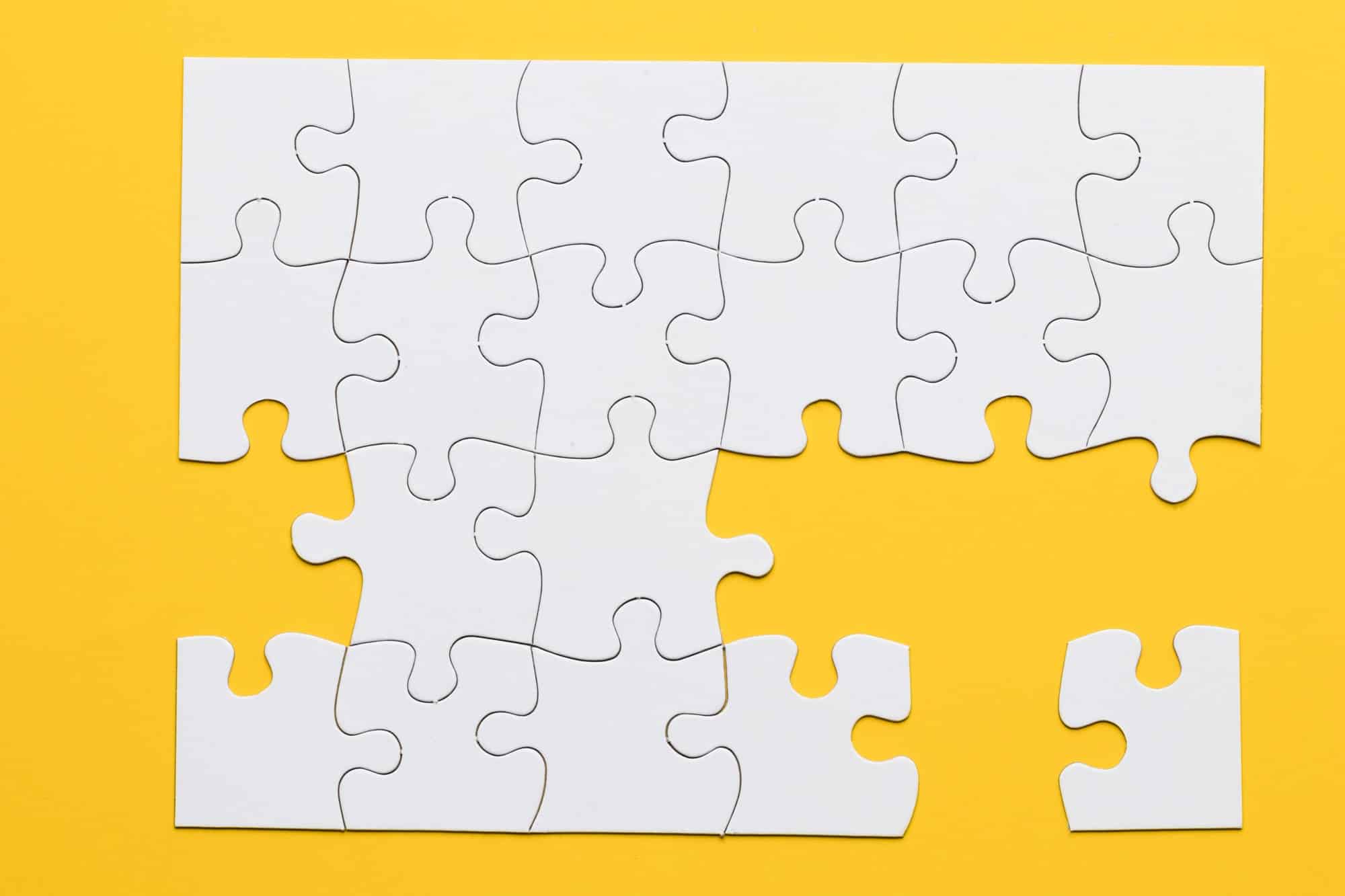 white-cardboard-jigsaw-puzzles-yellow-background